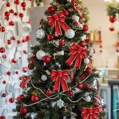 a decorated christmas tree with red bows and ornaments