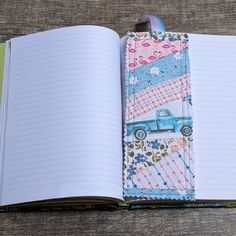 an open notebook with a blue truck on the front and pink flowers on the back