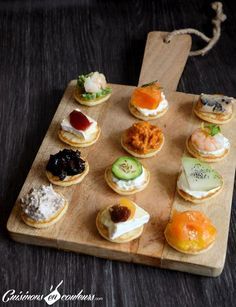 a wooden board topped with lots of small sandwiches