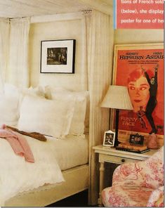 a bed with white linens and pillows in a bedroom next to a lamp on a table