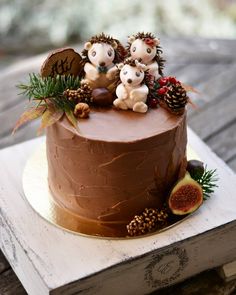 a chocolate cake decorated with figurines and pine cones