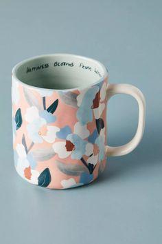 a pink and blue coffee cup with flowers on it