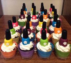 cupcakes decorated with colorful frosting and black top hats are arranged on a wooden table