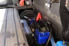 some wires are plugged into the back of a vehicle's battery compartment with other electrical equipment