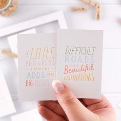 two cards that say difficult roads and beautiful destinations in different colors on white paper with gold lettering