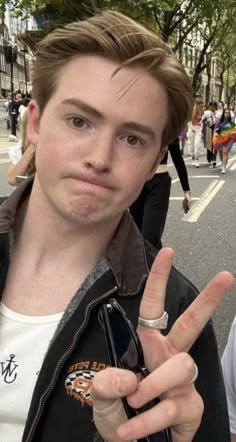 a young man making the peace sign with his fingers