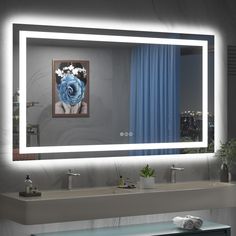 a bathroom sink with a large mirror above it and lights on the wall behind it