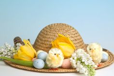 a straw hat with flowers, eggs and chicks on it