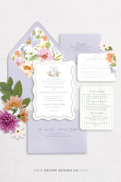 the wedding stationery is laid out with flowers