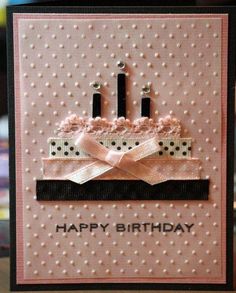 a pink birthday card with two candles on it and polka doted ribbon around the edges