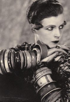 an old photo of a woman with rings around her neck