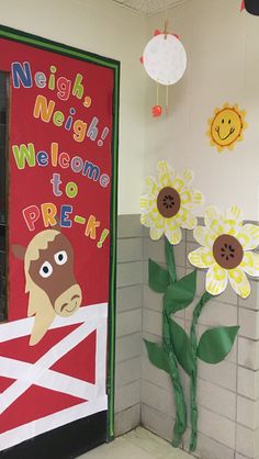 a door decorated with paper flowers and the words welcome to pre - k