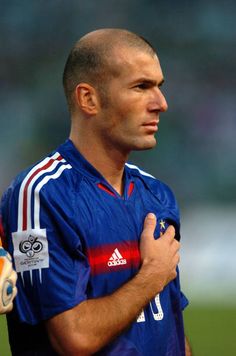 a man with a bald head holding a baseball glove on his left hand and looking off to the side