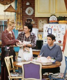 three people standing around a table with food in front of them and one person holding a bag