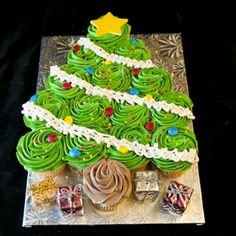 a christmas tree made out of cupcakes on top of a glass platter