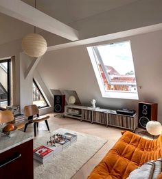 a living room filled with lots of furniture next to a large window covered in skylights