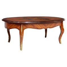 a wooden table with gold trimmings on the top and bottom, inlaid to an oval shape