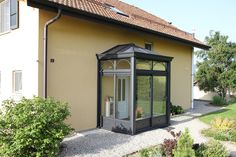 an orange house with a black roof and glass windows