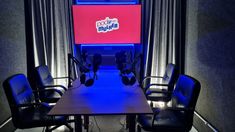 an empty conference room with chairs and a large screen in the background that says good nightlife