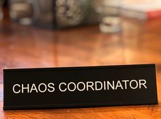 a close up of a sign on a table that says chaos coordinator