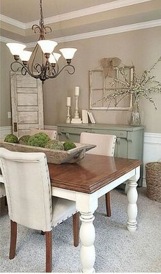 a dining room table with chairs and a bowl of moss on it's centerpiece