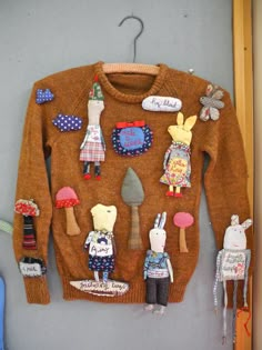 an ugly sweater is hanging on the wall with other things attached to it and some scissors