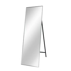 a mirror that is standing up against a white wall with a black frame on it