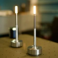 two silver candles are sitting on a table