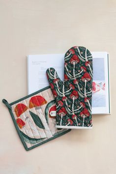 two oven mitts are next to an open book