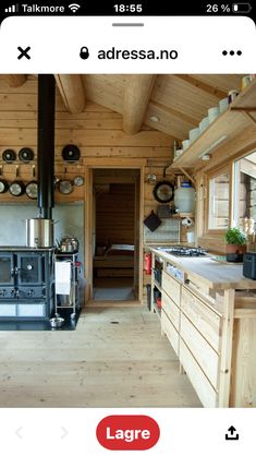 an image of a log cabin kitchen with wood flooring and stove in the center