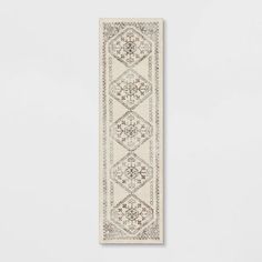 a beige and white runner rug hanging on a wall