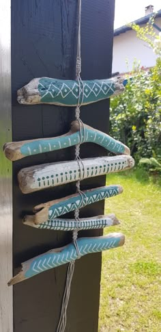 some wooden sticks are hanging on the side of a building with blue and white designs