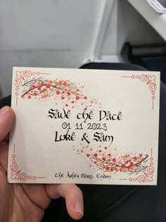 a person holding up a business card with an orange and red design on it that says silk cove place