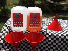 three red funnel cups sitting on top of a checkered table cloth next to two jugs