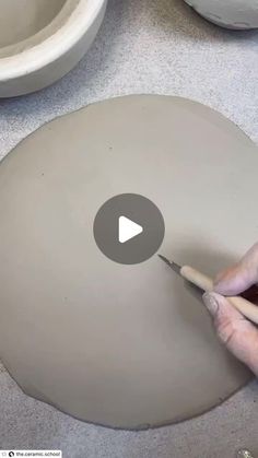 a person is painting a bowl with white paint