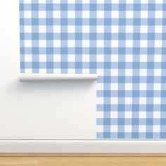 a blue and white checkered wallpaper in an empty room with wood flooring