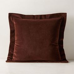 two brown velvet pillows sitting on top of each other