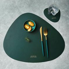 a place mat with food on it next to two forks and a bowl of lemons