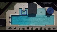 an aerial view of a swimming pool with umbrellas