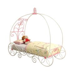 a white metal bed with a pink canopy and teddy bear sitting on the pillow in it