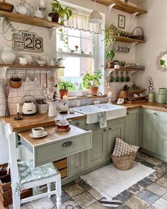 a kitchen filled with lots of green cupboards and counter top next to a window