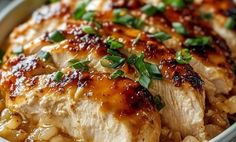 a close up of a plate of food with meat and rice on it, topped with green garnishes