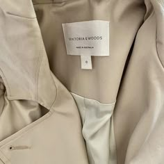 a label on a jacket that says victoria woods in white letters and is attached to the back of it