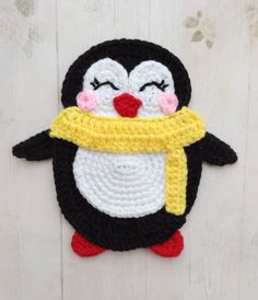 a crocheted penguin with a yellow scarf