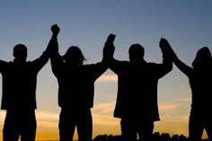 silhouettes of four people holding their hands up in the air