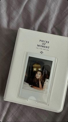 a polaroid photo frame sitting on top of a bed