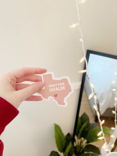 a person holding up a sticker that says pray for duvale in front of a bed