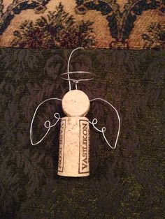 an angel made out of wine corks sitting on top of a carpeted floor