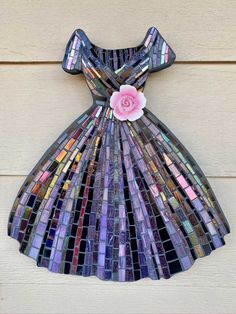 a dress made out of stained glass with a pink flower on the front and side