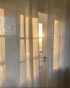 the sun is shining through the sheer curtains